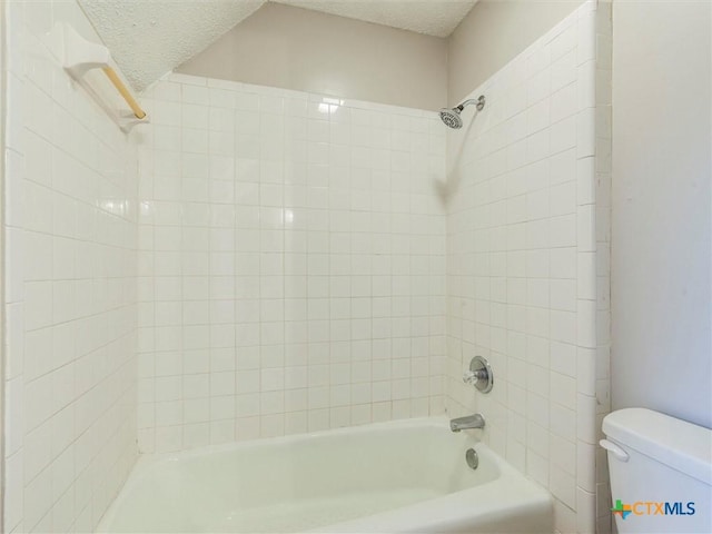 bathroom with tiled shower / bath combo, toilet, and a textured ceiling