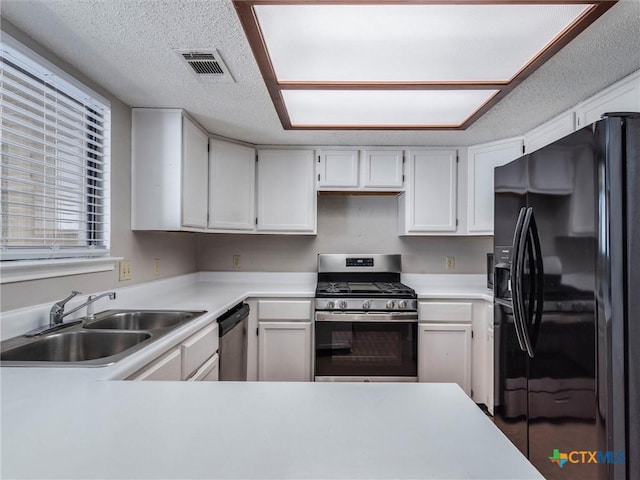 kitchen featuring a textured ceiling, sink, white cabinetry, and stainless steel appliances