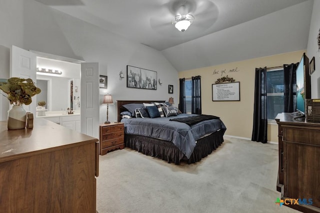 carpeted bedroom featuring lofted ceiling, ceiling fan, and ensuite bath