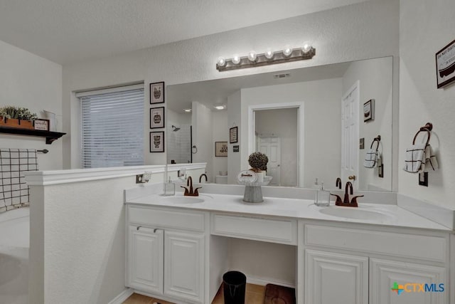 bathroom with vanity, shower with separate bathtub, and a textured ceiling