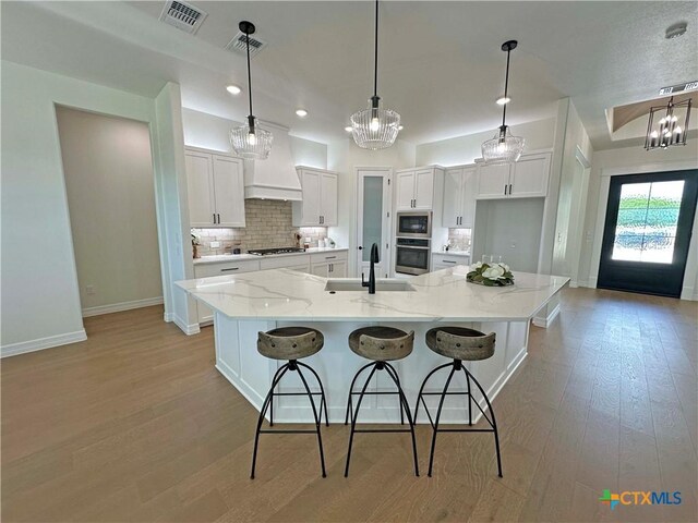 4316 Sunflower Ln, Temple, TX 76502 - kitchen featuring stainless steel appliances, open floor plan, dark wood-style flooring, white cabinetry, and a kitchen breakfast bar