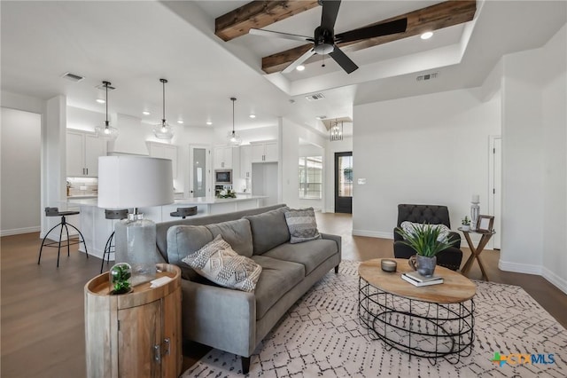 living room with wood-type flooring, beamed ceiling, and ceiling fan