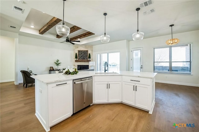 kitchen with pendant lighting, sink, dishwasher, white cabinets, and light wood-type flooring