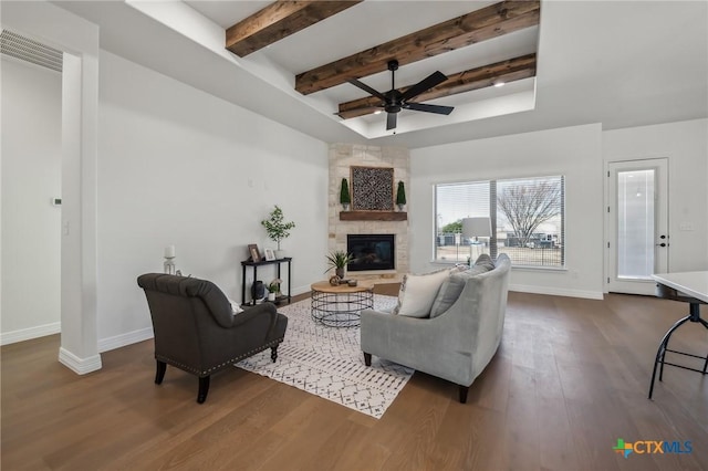 living room with dark wood-type flooring, a large fireplace, and ceiling fan