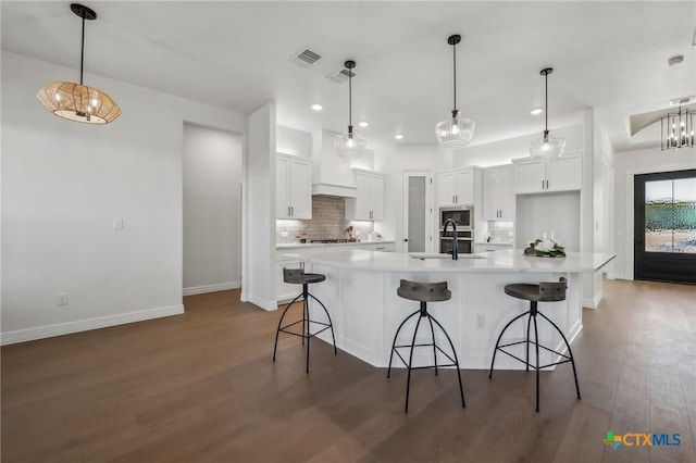 kitchen with pendant lighting, backsplash, sink, and white cabinets