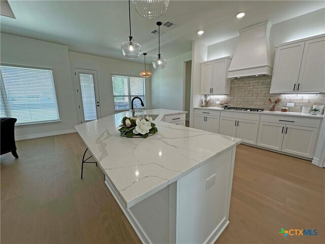 4316 Sunflower Ln, Temple, TX 76502 - kitchen featuring stainless steel appliances, dark wood-style flooring, white cabinetry, decorative backsplash, and a large island