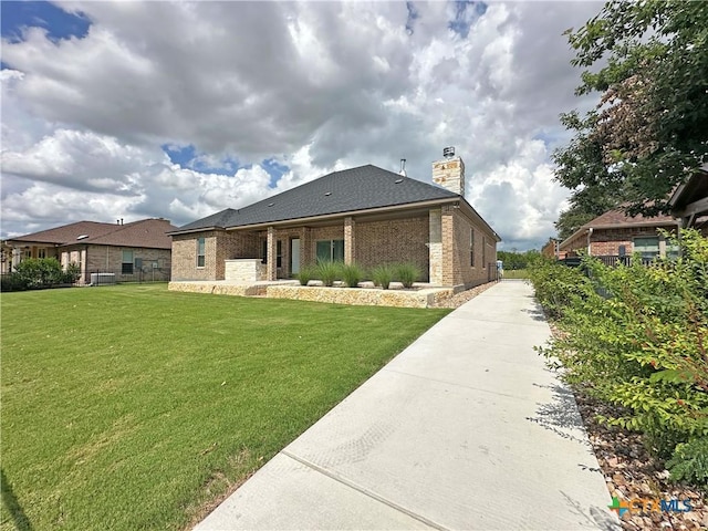 4316 Sunflower Ln, Temple, TX 76502 - view of front of home featuring a chimney, brick siding, and a front yard