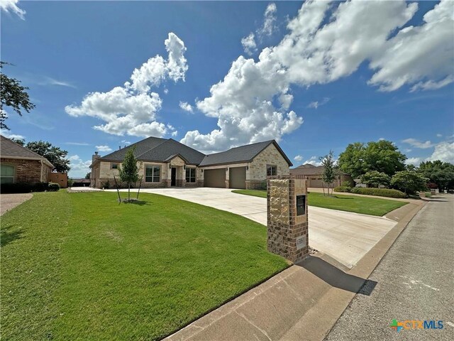 4316 Sunflower Ln, Temple, TX 76502 - french country style house featuring a garage, driveway, stone siding, and brick siding