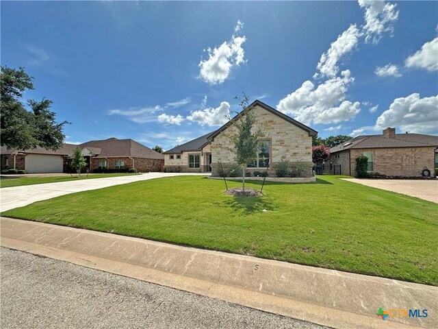 4316 Sunflower Ln, Temple, TX 76502 - french provincial home with stone siding, an attached garage, concrete driveway, and brick siding