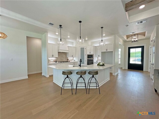 4316 Sunflower Ln, Temple, TX 76502 - kitchen with appliances with stainless steel finishes, light wood-style flooring, white cabinetry, a spacious island, and recessed lighting