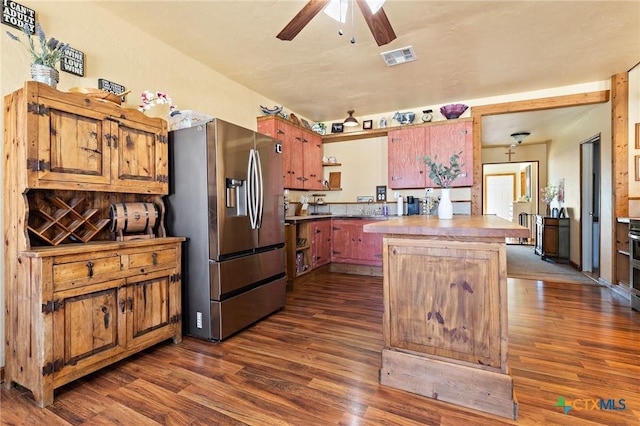 kitchen featuring a ceiling fan, stainless steel fridge, visible vents, and dark wood-type flooring