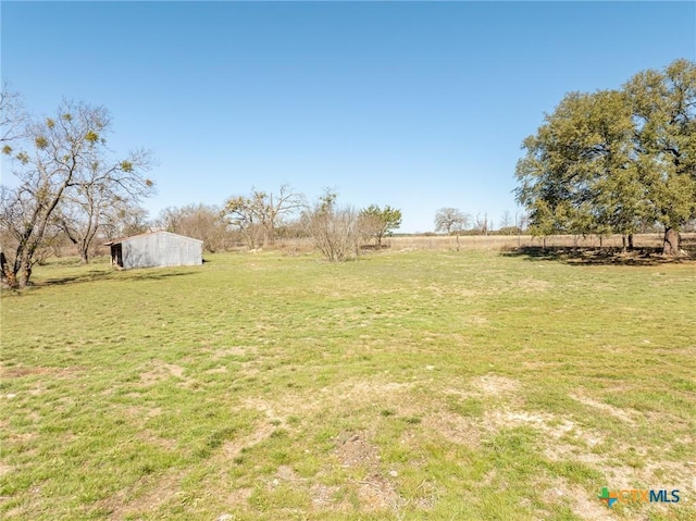 view of yard featuring an outdoor structure and a rural view