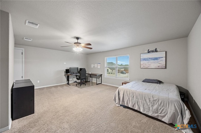 carpeted bedroom with visible vents, ceiling fan, a textured ceiling, and baseboards