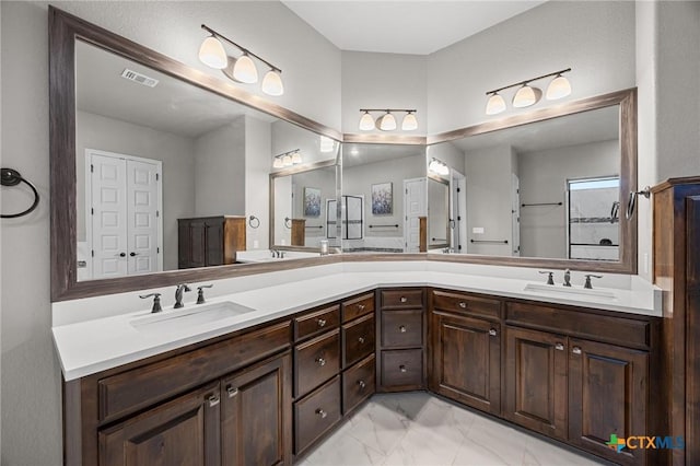 full bath with a sink, visible vents, marble finish floor, and double vanity