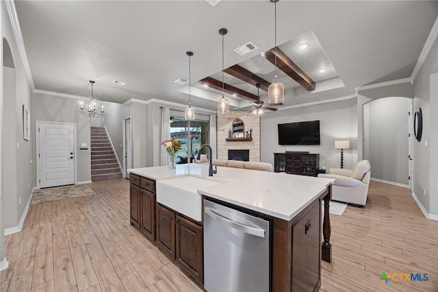 kitchen with visible vents, a fireplace, arched walkways, a sink, and stainless steel dishwasher