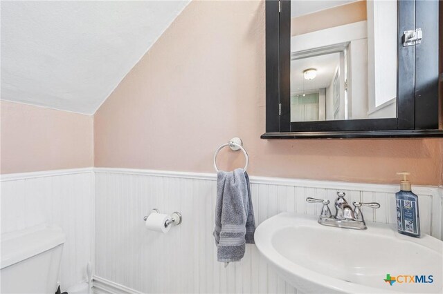 1004 Mitchell St, Gonzales, TX 78629 - half bath featuring a wainscoted wall and lofted ceiling