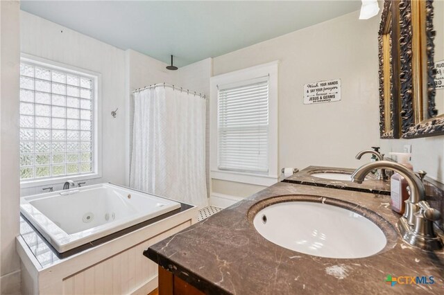 1004 Mitchell St, Gonzales, TX 78629 - full bathroom featuring a tub with jets, double vanity, and a shower with curtain
