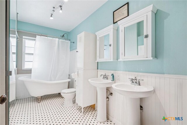 1004 Mitchell St, Gonzales, TX 78629 - full bath with a wainscoted wall and toilet