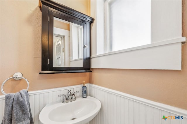 1004 Mitchell St, Gonzales, TX 78629 - bathroom with a wainscoted wall and a decorative wall