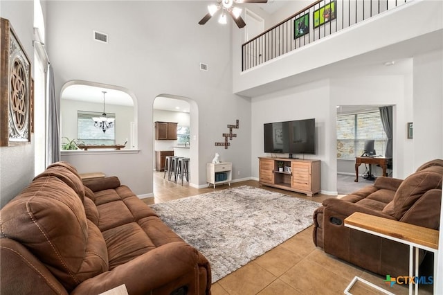 11602 Buster Crabbe Dr, Austin, TX 78748 - living area featuring light tile patterned floors, arched walkways, a ceiling fan, and a towering ceiling