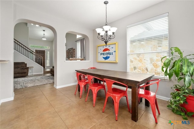 11602 Buster Crabbe Dr, Austin, TX 78748 - dining room with a chandelier, arched walkways, tile patterned floors, and stairs