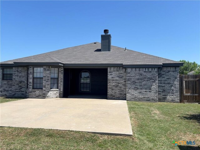 4207 Hitchrock Dr, Killeen, TX 76549 - rear view of property with fence, a yard, brick siding, and a chimney
