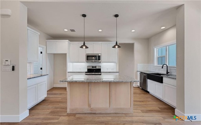 1435 Redwood Rd, Fischer, TX 78623 - kitchen with stainless steel appliances, a sink, tasteful backsplash, white cabinets, and recessed lighting