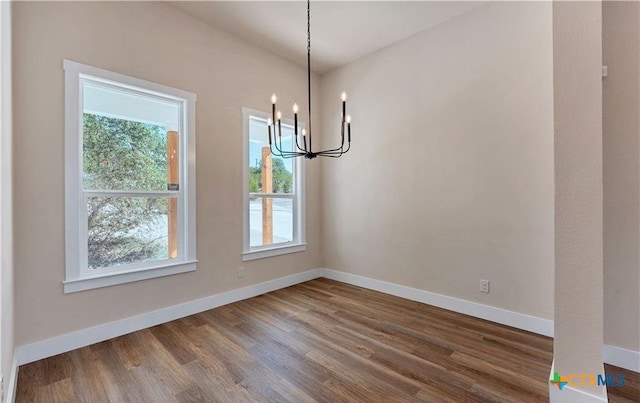 1435 Redwood Rd, Fischer, TX 78623 - unfurnished dining area featuring plenty of natural light, a chandelier, dark wood-style floors, and baseboards