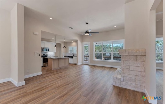 1435 Redwood Rd, Fischer, TX 78623 - unfurnished living room with baseboards, ceiling fan, healthy amount of natural light, light wood-type flooring, and recessed lighting