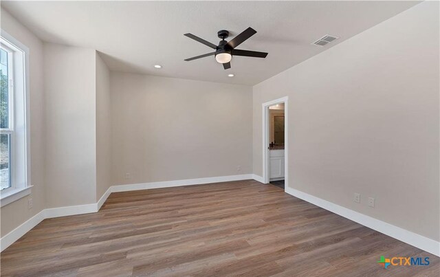 1435 Redwood Rd, Fischer, TX 78623 - empty room with healthy amount of natural light, a ceiling fan, wood finished floors, recessed lighting, and baseboards