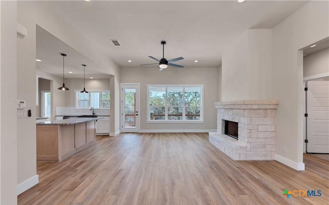 1435 Redwood Rd, Fischer, TX 78623 - unfurnished living room featuring light wood-style flooring, a ceiling fan, recessed lighting, a sink, and baseboards