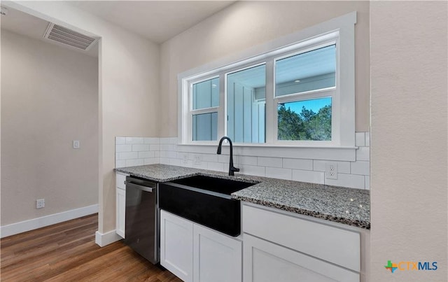 1435 Redwood Rd, Fischer, TX 78623 - kitchen with stone counters, stainless steel dishwasher, decorative backsplash, and white cabinets