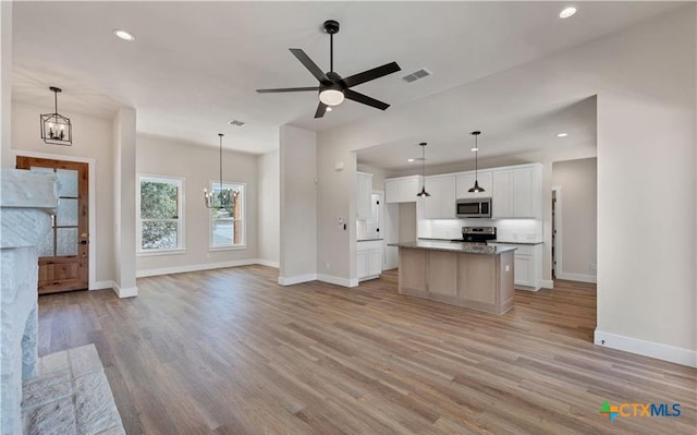1435 Redwood Rd, Fischer, TX 78623 - kitchen with stainless steel appliances, open floor plan, baseboards, light wood-style flooring, and recessed lighting