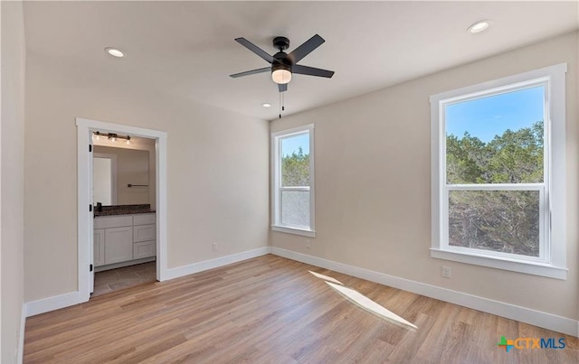 1435 Redwood Rd, Fischer, TX 78623 - unfurnished bedroom with light wood finished floors, baseboards, recessed lighting, and ensuite bath