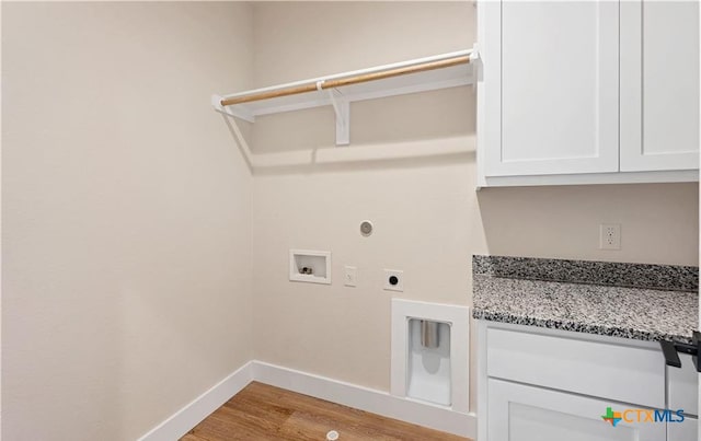 1435 Redwood Rd, Fischer, TX 78623 - clothes washing area with hookup for a washing machine, hookup for an electric dryer, baseboards, light wood-style flooring, and cabinet space