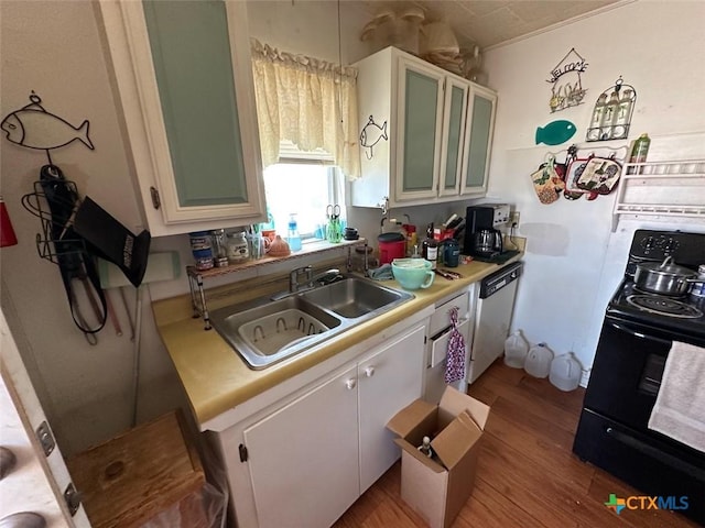 415 S 15th St, Port Oconnor, TX 77982 - kitchen featuring black / electric stove, light countertops, dishwashing machine, a sink, and light wood-style flooring