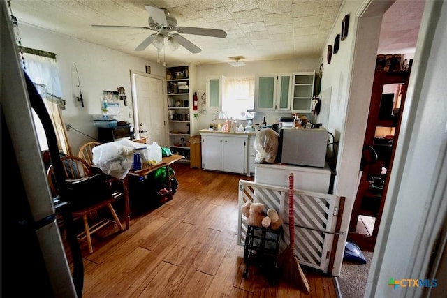 415 S 15th St, Port Oconnor, TX 77982 - kitchen featuring decorative light fixtures, open shelves, ceiling fan, wood-type flooring, and white cabinetry