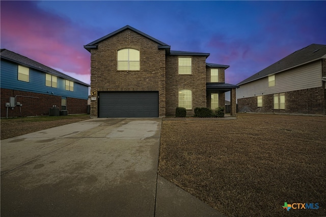 view of front of property featuring a garage and central AC