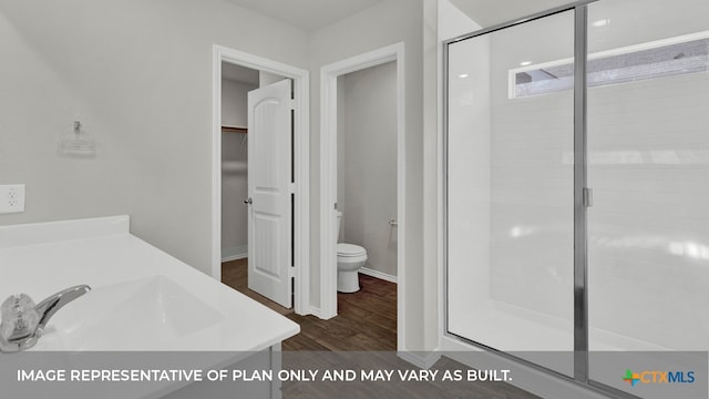 bathroom featuring hardwood / wood-style floors, vanity, toilet, and an enclosed shower