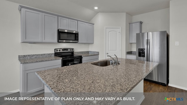 kitchen with dark wood-type flooring, sink, an island with sink, appliances with stainless steel finishes, and light stone counters