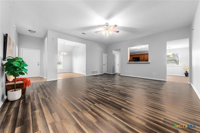 living room with ceiling fan with notable chandelier, dark wood-type flooring, and pool table