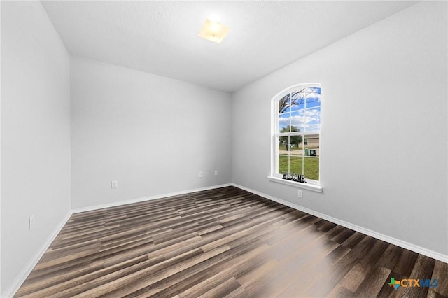 spare room with dark wood-type flooring