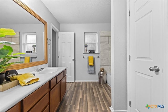 bathroom with bathing tub / shower combination, vanity, wood-type flooring, and a textured ceiling