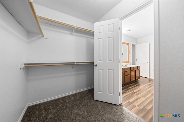 spacious closet featuring dark colored carpet