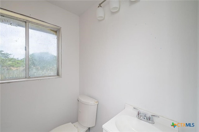 120 Retama Ln, Rockport, TX 78382 - half bathroom with toilet, a sink, and a wealth of natural light