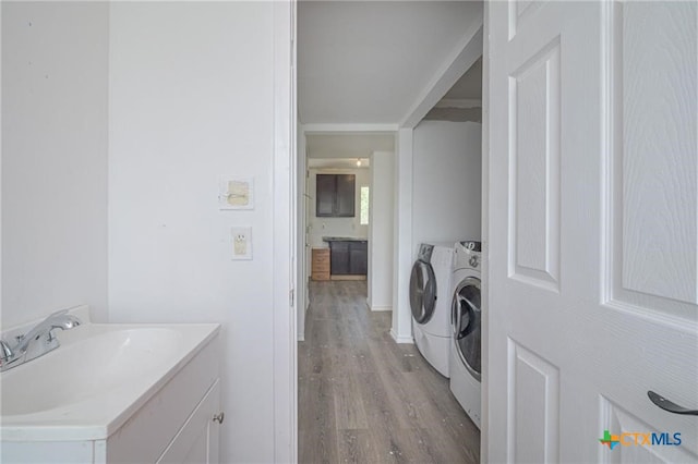 120 Retama Ln, Rockport, TX 78382 - laundry area with washer and dryer, a sink, laundry area, and light wood-type flooring