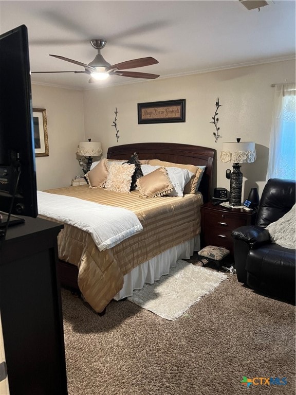 bedroom with ceiling fan, ornamental molding, and carpet