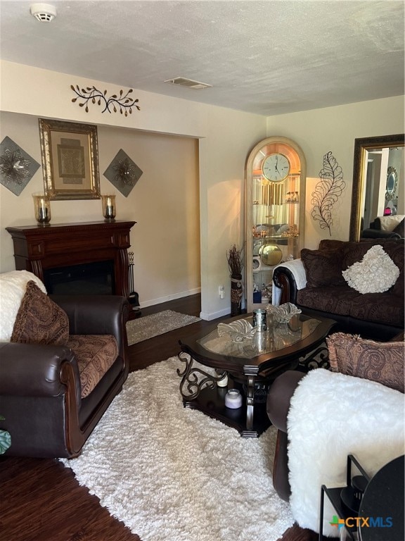 living room featuring dark hardwood / wood-style flooring and a textured ceiling