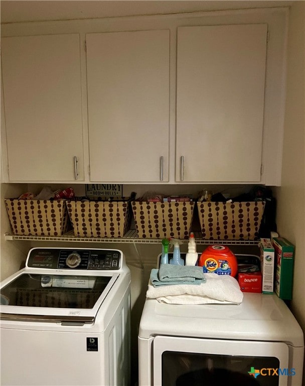 washroom with washing machine and dryer and cabinets