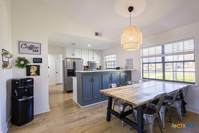 dining area with lofted ceiling and light wood-type flooring